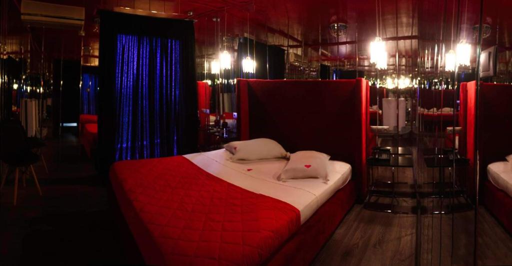 1 dormitorio con 1 cama roja y 2 almohadas en KATRINA HOTEL, en Skaramangás