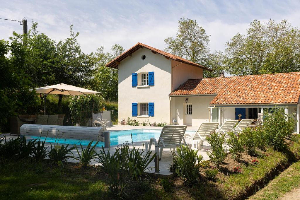 eine Villa mit einem Pool vor einem Haus in der Unterkunft La Métairie - Guesthouse in Orx