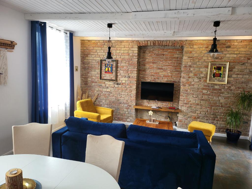 a living room with blue furniture and a brick wall at Moderne, stilvolle Ferienwohnung in Stralsund 84m2 in Stralsund