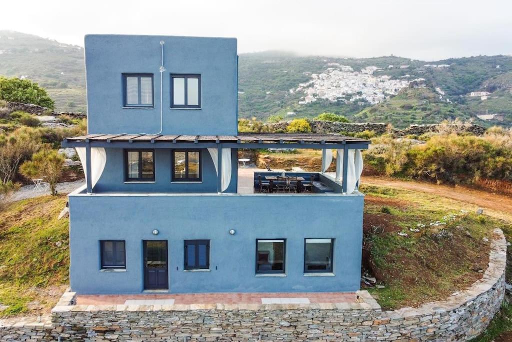 una casa azul sentada en la cima de una colina en Villa Esmeralda Kea, en Fotimárion