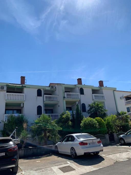 a white car parked in front of a building at Apartmani Borić in Vantačići