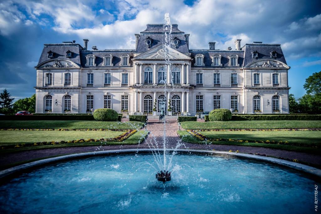 a mansion with a fountain in front of it at Château D'artigny in Montbazon
