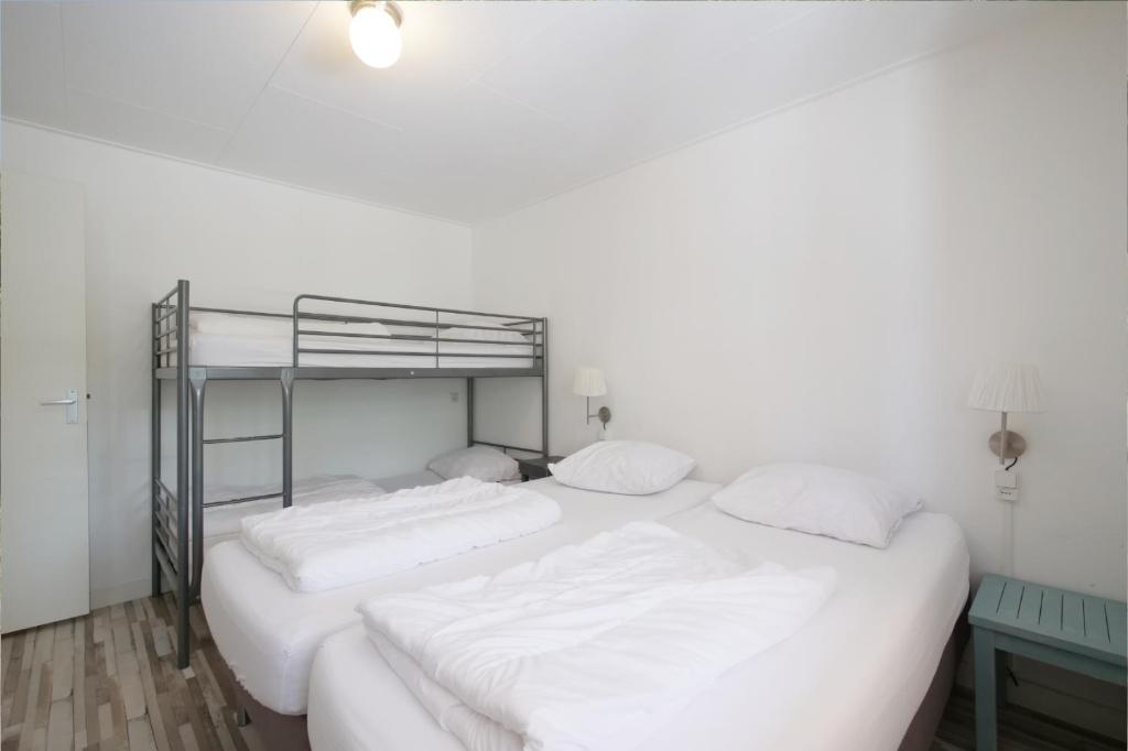 デン・ヘルダーにあるPakhuys Lodge - Oudの白いベッドルーム(白いシーツを使用した二段ベッド付)