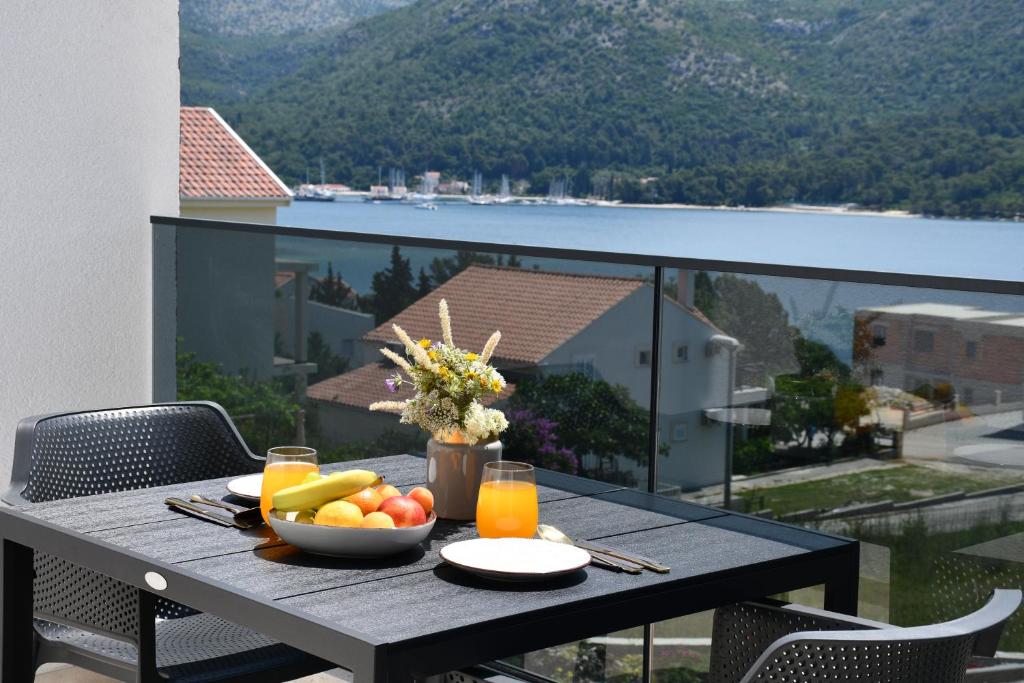 a table with a bowl of fruit and juice on a balcony at Luxury Villa Salt in Slano