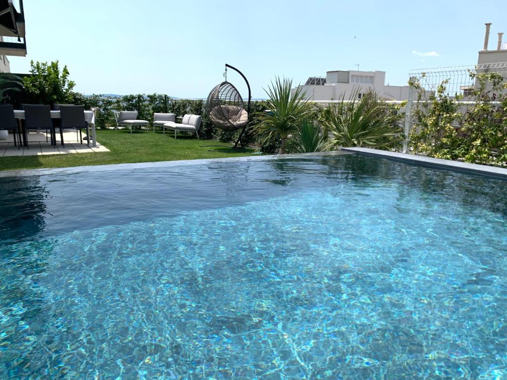a swimming pool with blue water in a yard at Luxury apartment Enjoyer - PRIVATE POOL with a large garden and private garage in Split