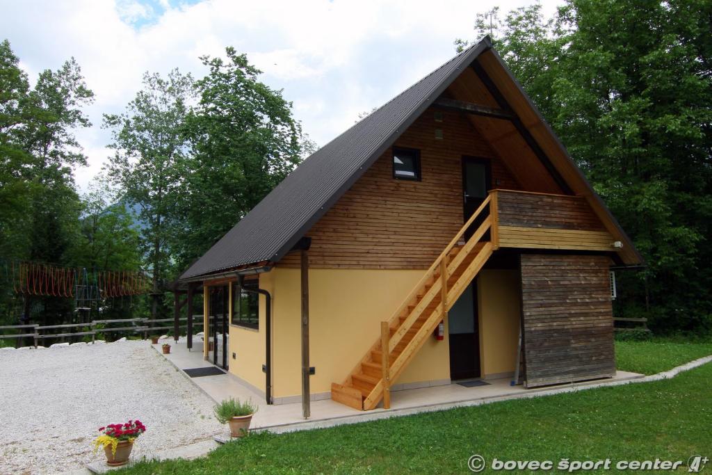 une petite maison avec un toit en gambrel dans l'établissement Base camp - Apartments & Rooms, à Bovec