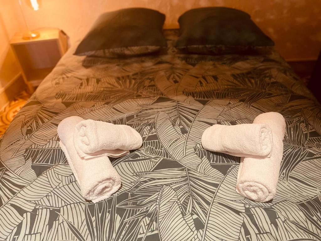 a bed with two towels on top of it at Cocon douillet à Agde in Agde