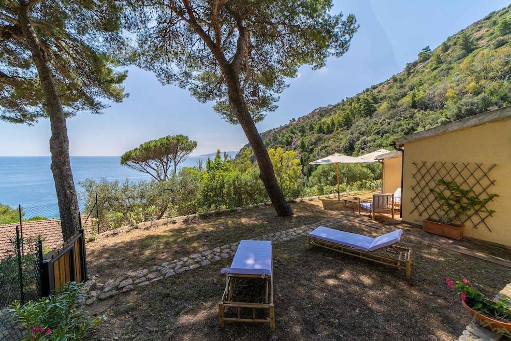 un patio con mesa, sillas y el océano en Villetta indipendente sul Mare, en Monte Argentario