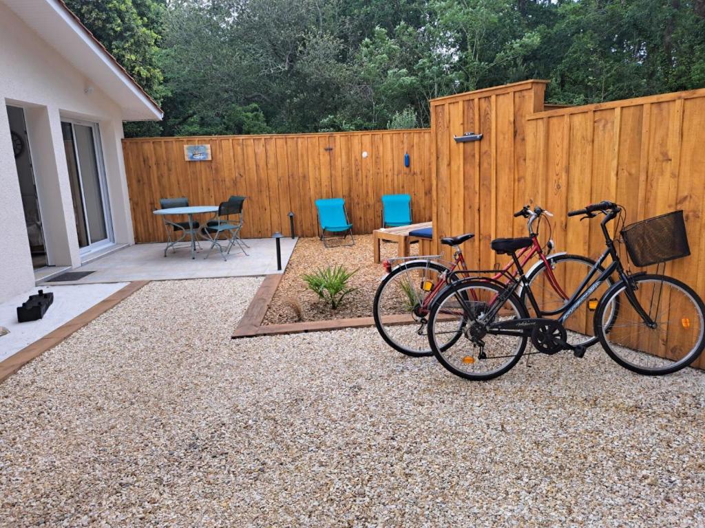 due biciclette parcheggiate di fronte a una recinzione di La Petite Perle a Andernos-les-Bains