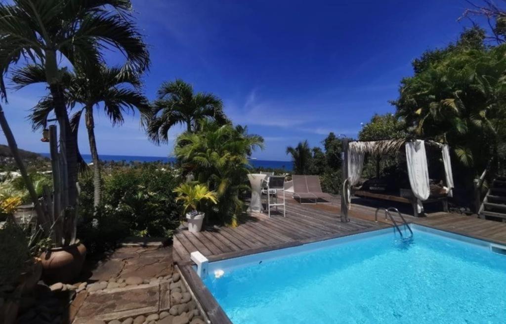 a swimming pool with a view of the ocean at Ali-Naïs Location in Deshaies
