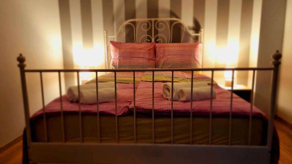 a bed with a pink blanket and pillows on it at Apartament G66 in Wydminy