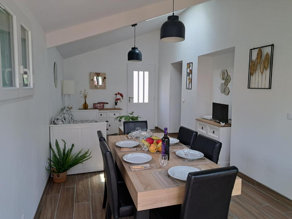 une table de salle à manger avec des chaises et une cuisine dans l'établissement maison de la plage et du golf, à Moliets-et-Maa