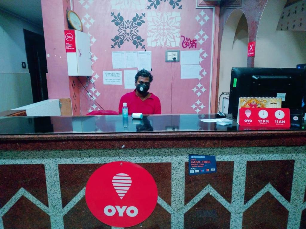 a man wearing a gas mask behind a counter at OYO Sai Sagar Residency in Bhubaneshwar