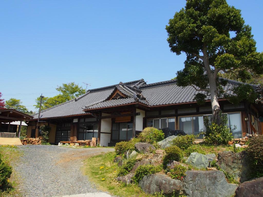 a house with a tree and a gravel road at Furuki in Mashiko