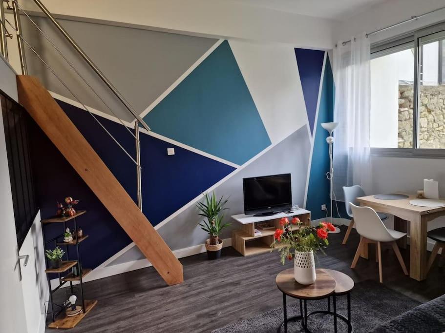 a living room with a blue and white wall at CASITA aux portes de paris in Bagneux