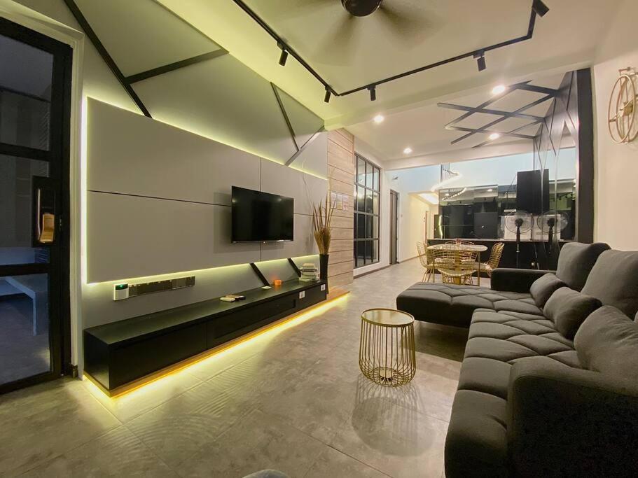 a living room with a couch and a flat screen tv at SIX Boutique Residence @ Ipoh Garden Landed House 8pax in Ipoh