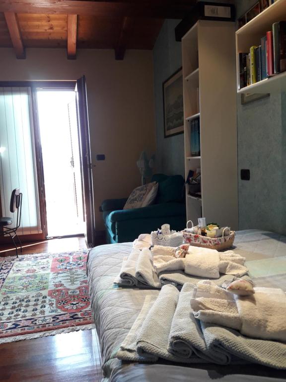 un grande letto in una stanza con asciugamani di Lovely Casa Paola a Villafranca di Verona