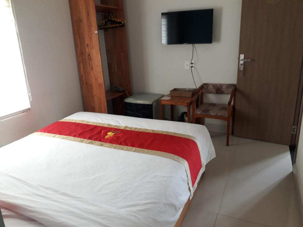 1 dormitorio con 1 cama, 1 silla y TV en Hotel Bảo Quang, en Phú Khê (2)