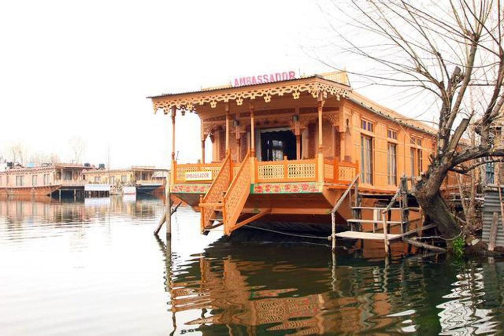 a boat in the water with a house on it at Houseboat Ambassador in Srinagar