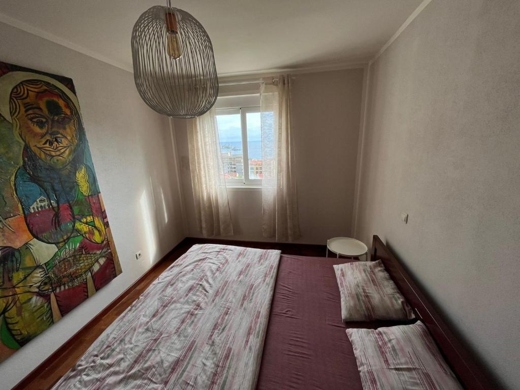 um quarto com uma cama grande e uma pintura na parede em b-612 em Petrovac na Moru
