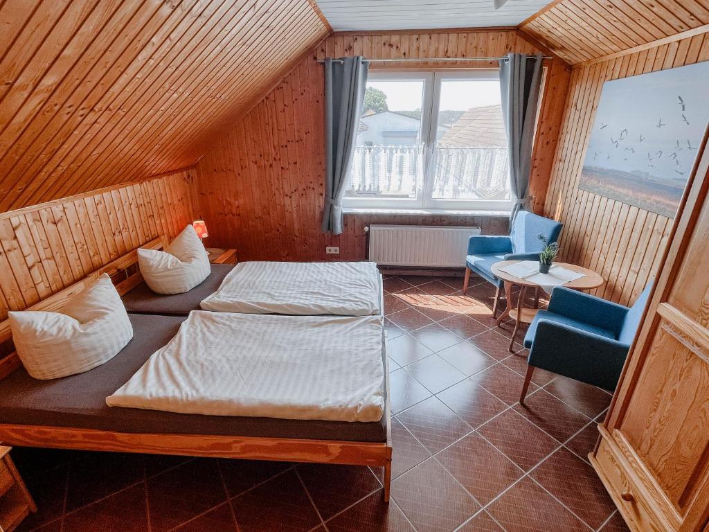 1 dormitorio con 1 cama, 2 sillas y ventana en Ferienwohnung 2, en Dargen