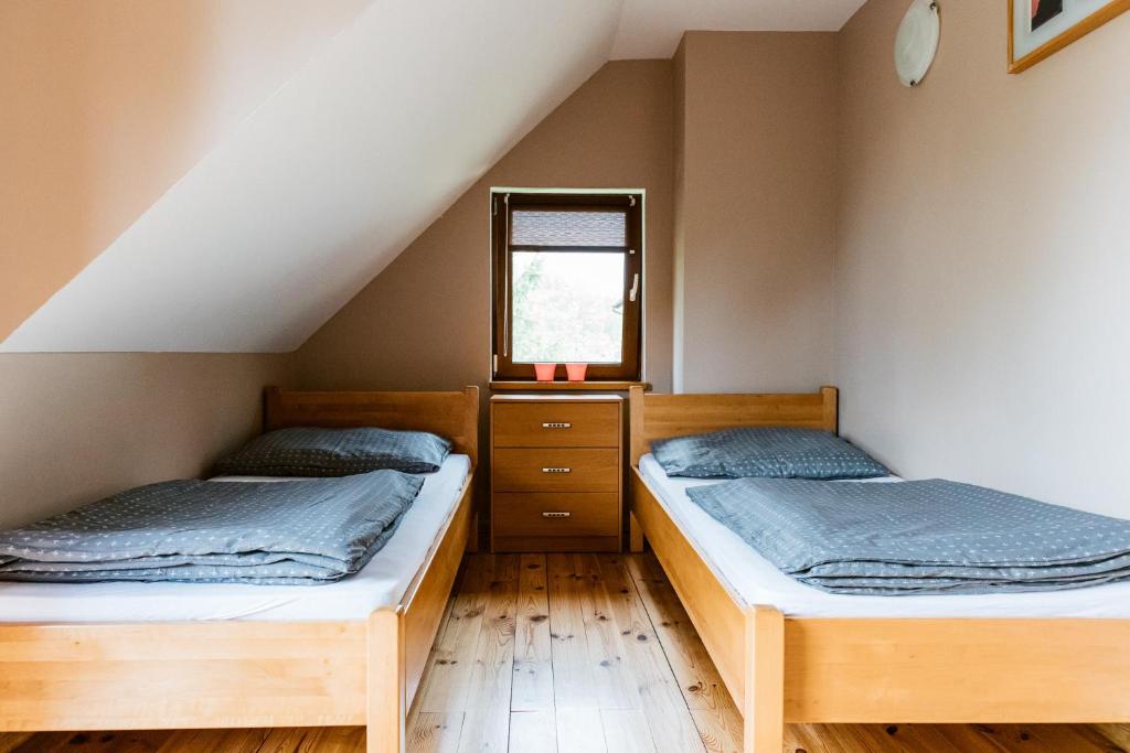 2 łóżka pojedyncze w pokoju z oknem w obiekcie Wataha - domek całoroczny nad jeziorem w mieście Mikołajki