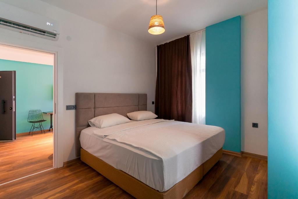 1 dormitorio con cama y pared azul en PASHAM RESIDENCE en Alanya