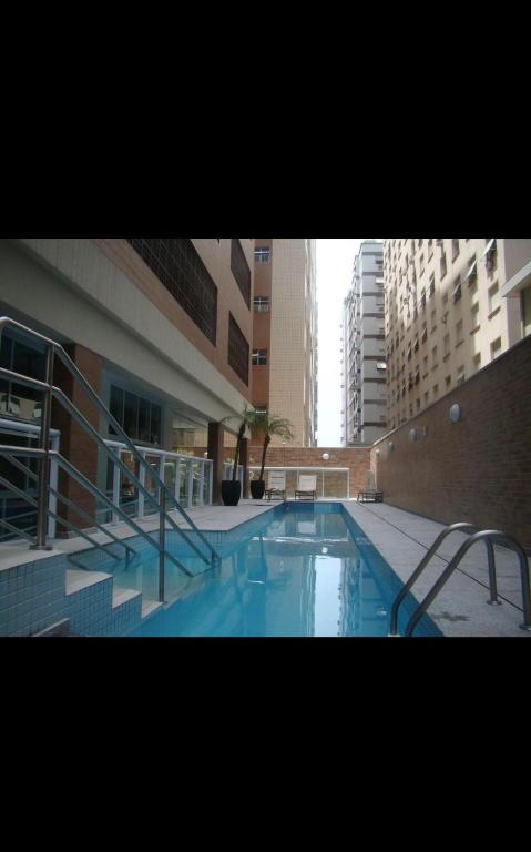 a swimming pool in the middle of a building at Estanconfor Santos 705 com estacionamento GRÁTIS in Santos