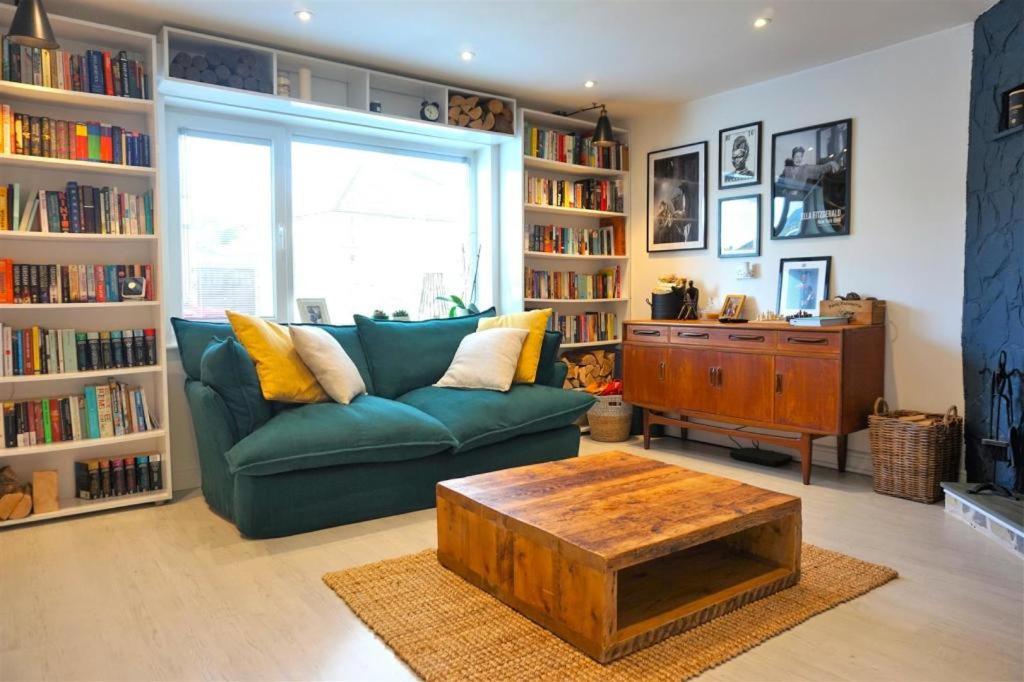 Lovely family home in Rainham, Kent في راينهام: غرفة معيشة مع أريكة خضراء وطاولة قهوة