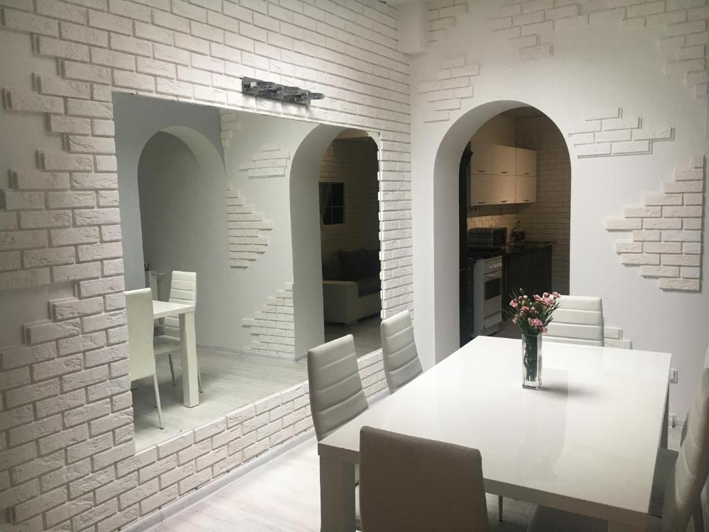 una sala da pranzo con tavolo e parete di mattoni bianchi di Apartament Konopnickiej a Dziwnów