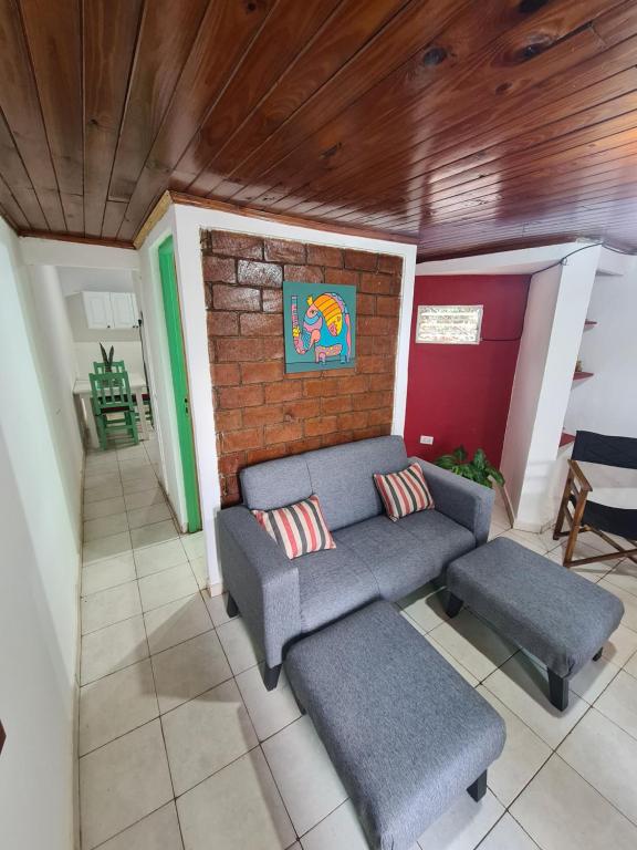 ein Wohnzimmer mit einem Sofa und 2 Stühlen in der Unterkunft Depto confortable para 4 Personas in Posadas
