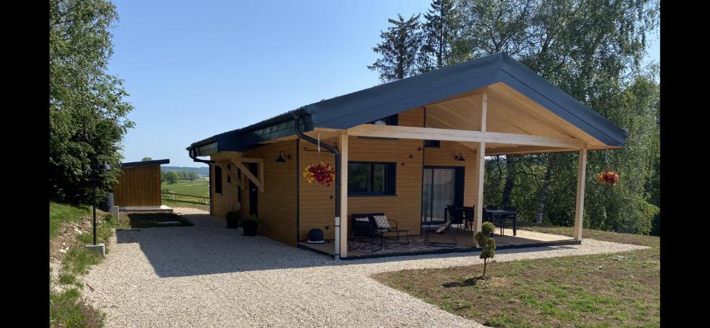ein kleines Haus mit blauem Dach in der Unterkunft Gîte chalet, Au Doubs Logis in Pierrefontaine-les-Varans