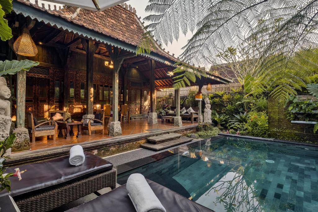 a villa with a swimming pool and a house at Roshan Ubud Villa in Ubud