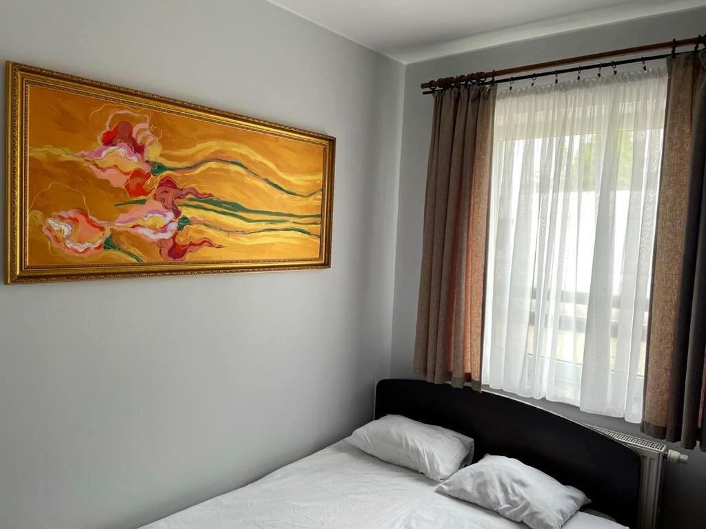 a bedroom with a bed and a painting on the wall at Irys 1 in Tychy