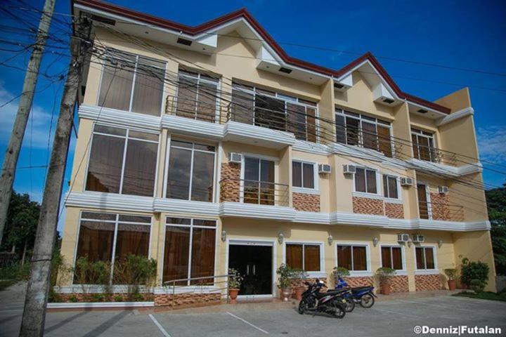 uma casa grande com duas motos estacionadas em frente em Aberrise Country Villa Pension Hotel em Dumaguete