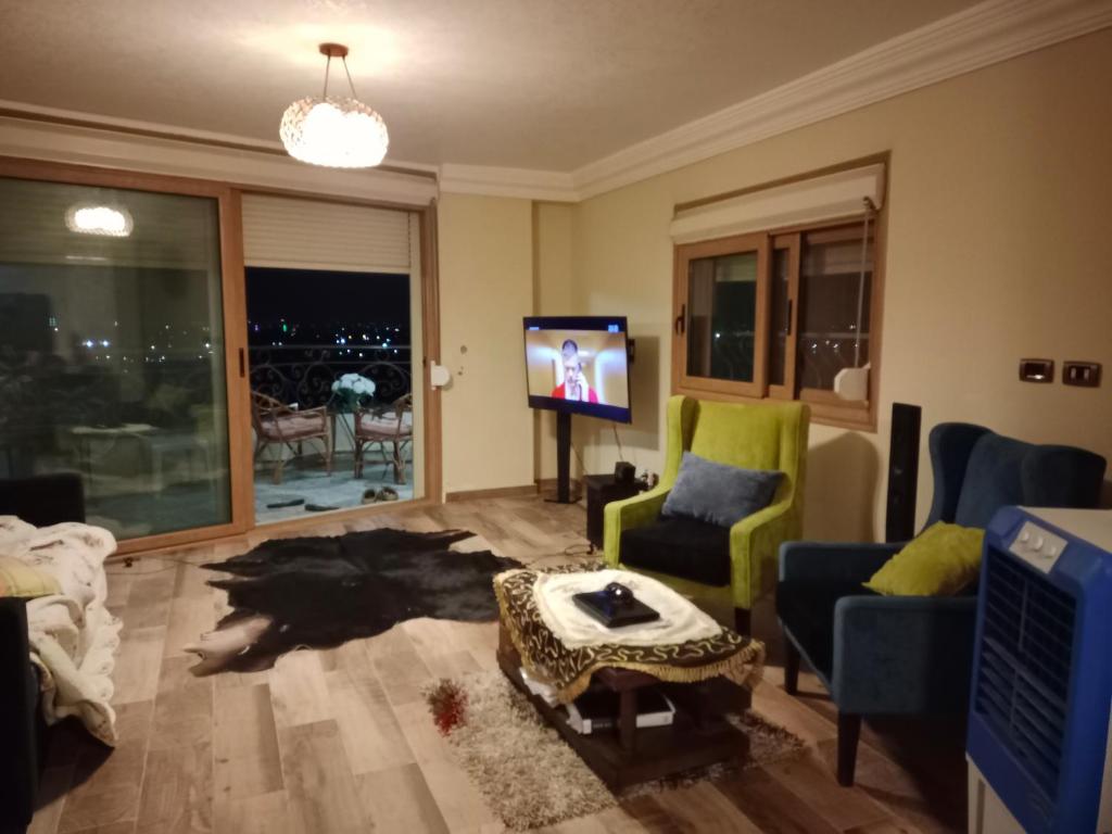 a living room with a couch and a tv at شقة على النيل بالمعادي in Cairo