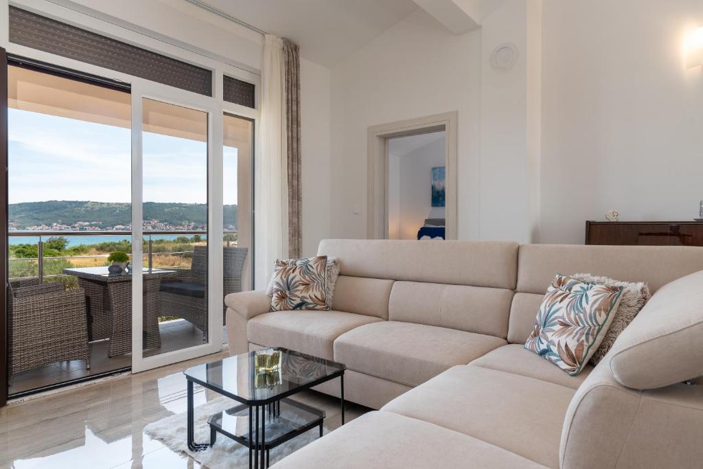 a living room with a couch and a glass table at Amazing sea view apartment- Romantica in Kastel Stafilic