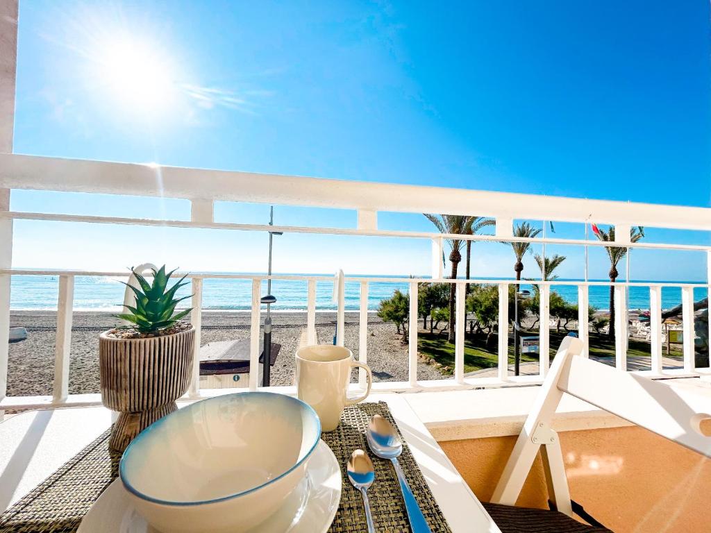a balcony with a table and a view of the beach at Apartment on the 1st line of the Sabinillas beach with sea views in San Luis de Sabinillas