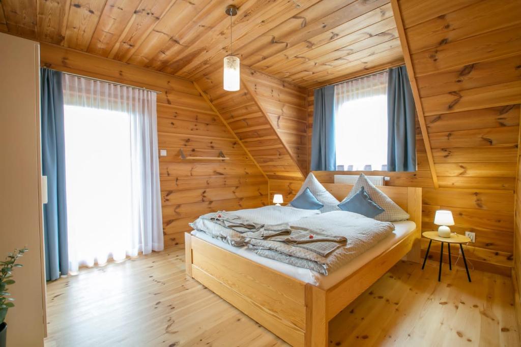 a bedroom with a bed in a log cabin at u Marysi in Polanica-Zdrój