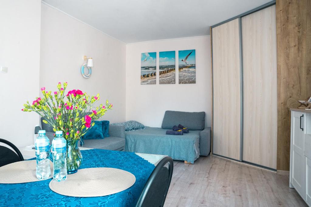 een woonkamer met een tafel met bloemen erop bij Słoneczny Apartament przy plaży in Gdańsk