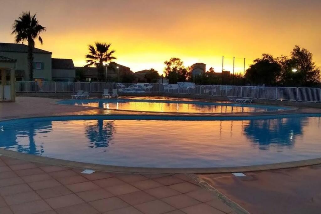 uma piscina vazia com um pôr-do-sol ao fundo em Un bol d'air frais et de soleil entre campagne et plage em Béziers