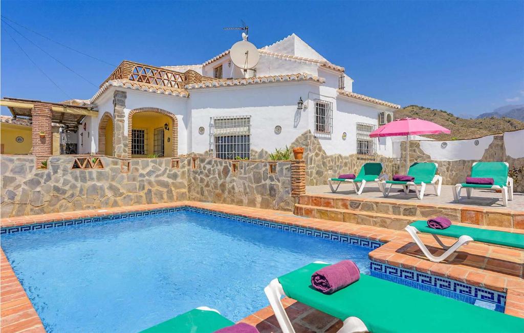a villa with a swimming pool in front of a house at Aranzazu in Frigiliana