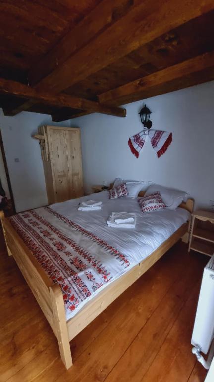 Cette chambre comprend un grand lit et du parquet. dans l'établissement Pensiunea Poienita Motilor, à Achimeţeşti