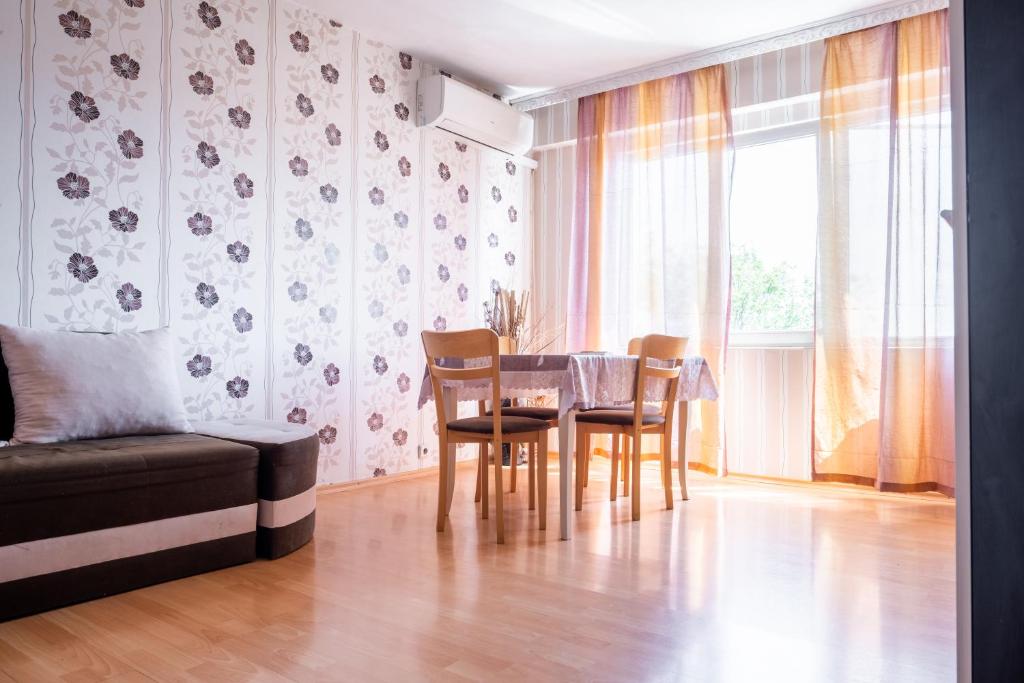 comedor con mesa, sillas y sofá en Apartment RUSE SUNRISE, en Ruse