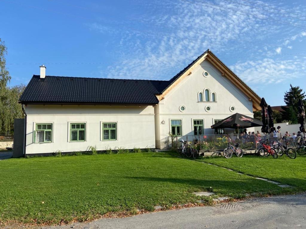a white house with a black roof and a yard at Pension Sodomkův statek Czap in Skuteč