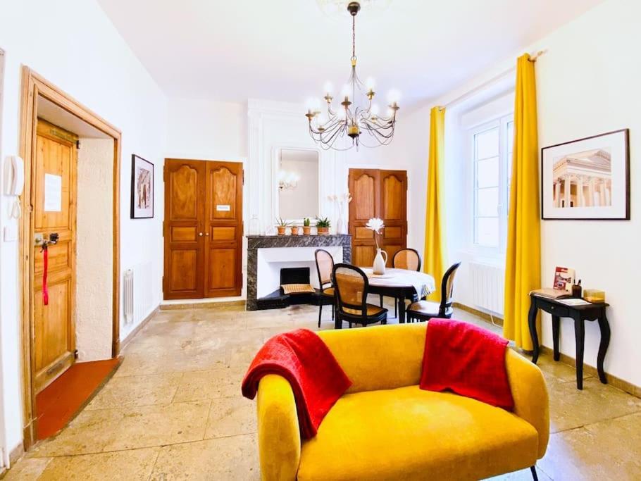 un salon avec un canapé jaune et une table dans l'établissement L'Occithalie Nîmes Ecusson 2 chambres 72m2, à Nîmes