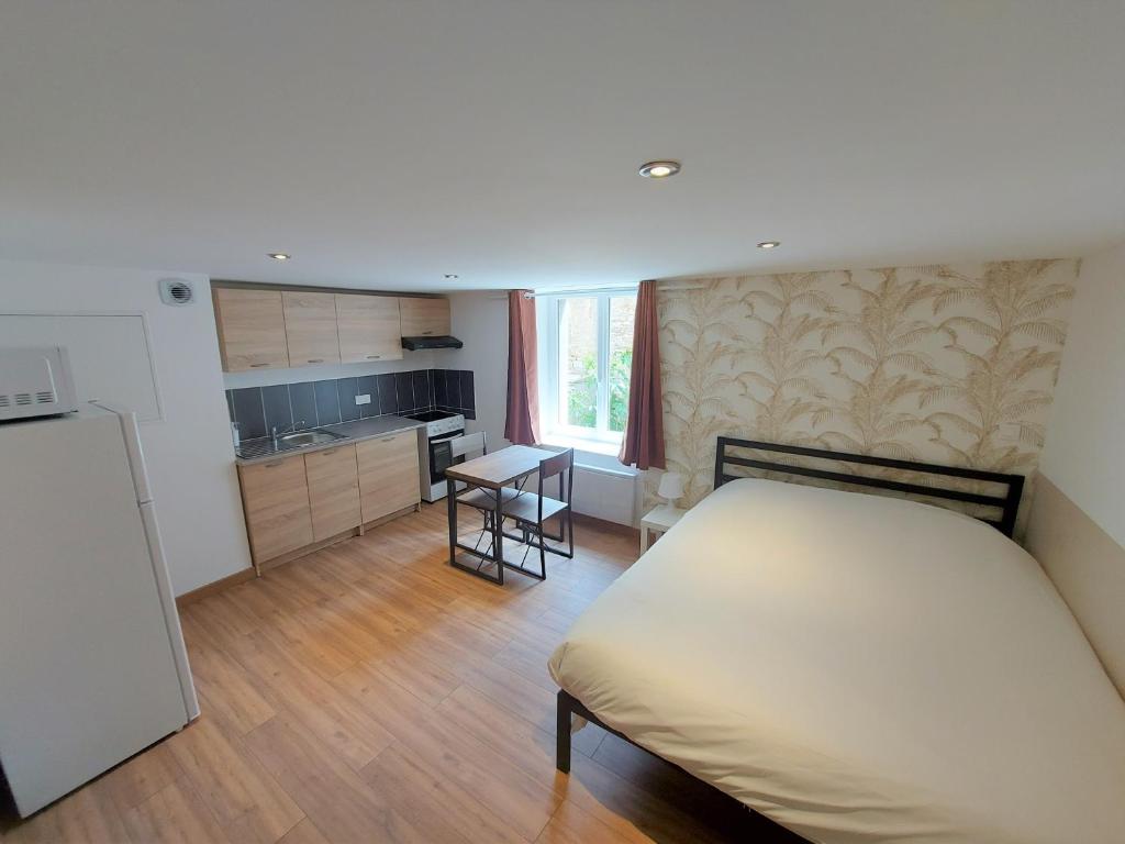 ein kleines Schlafzimmer mit einem Bett und einer Küche in der Unterkunft ° Studio 1 - Lunéville centre ° in Lunéville