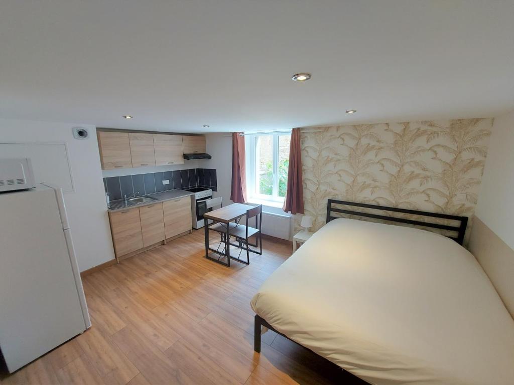 a small bedroom with a bed and a kitchen at ° Studio 1 - Lunéville centre ° in Lunéville