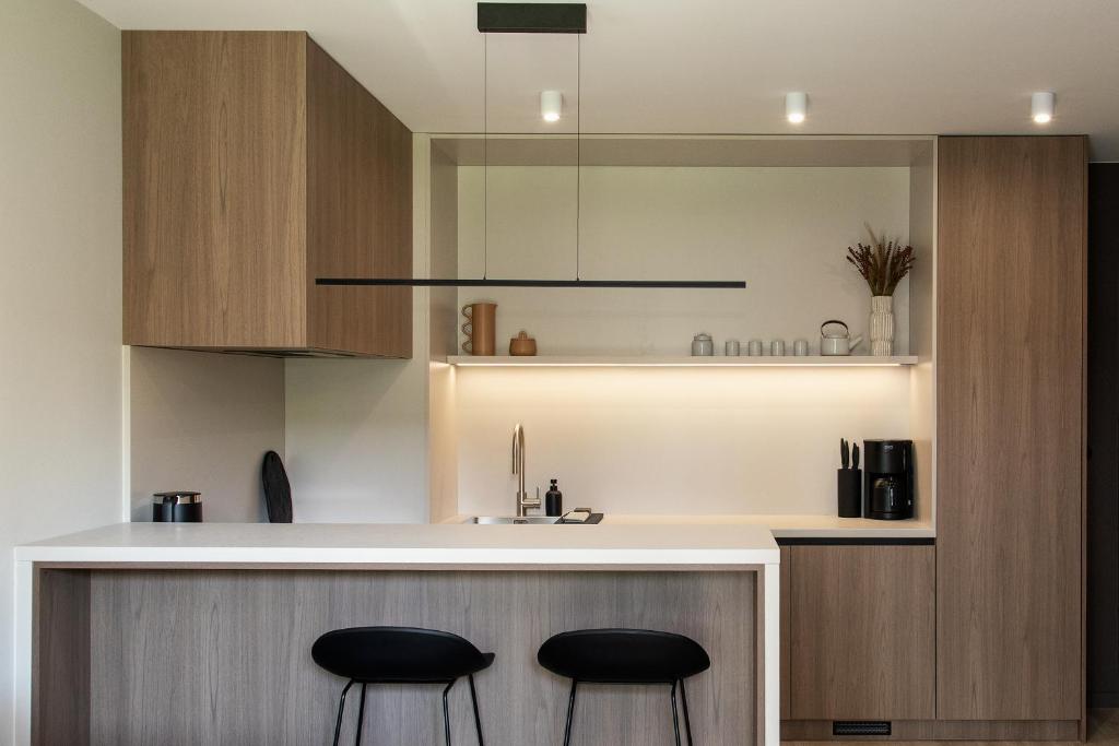a kitchen with two black stools at a counter at Apartament Legionów- A15 w centrum Kalisza in Kalisz