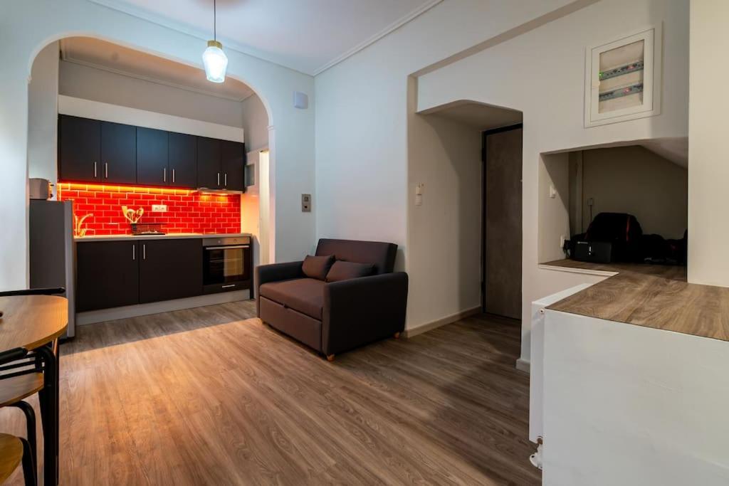 a living room with a couch and a kitchen at Studio Apartment next to Alsos Ilision in Athens